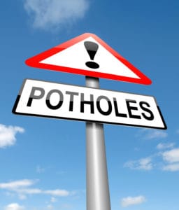 Potholes warning sign.